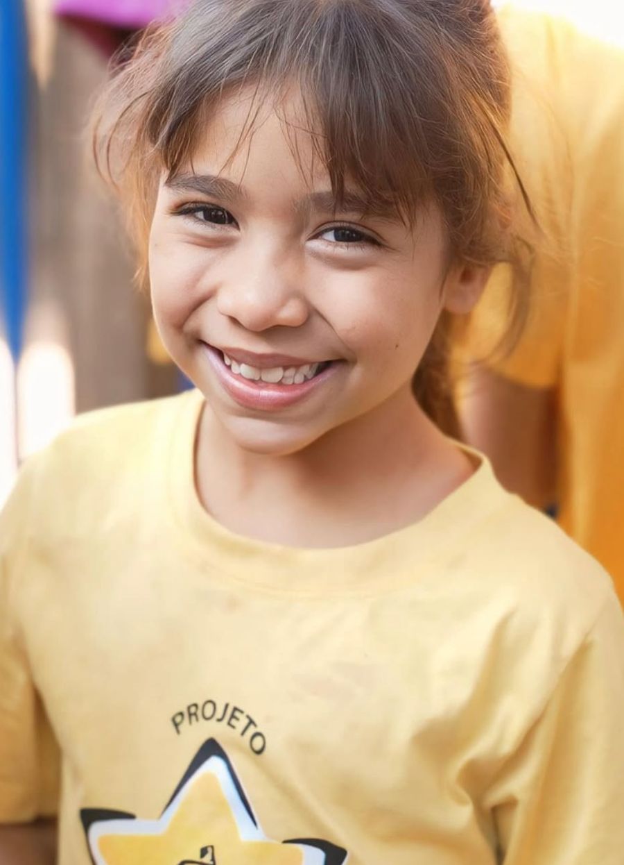 Menina sorrindo com a camiseta do Projeto Estrela Mãe